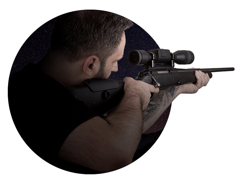 Hunter in the field using an ATN X-Sight optic at dusk