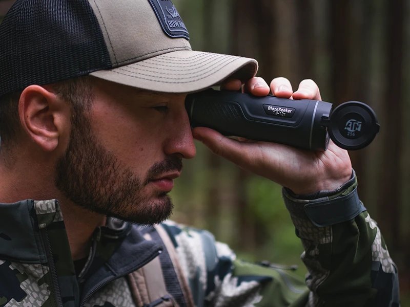 Hunter in the field using an ATN thermal clip-on at dusk