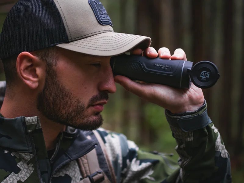 Hunter in the field using an ATN scope at dusk