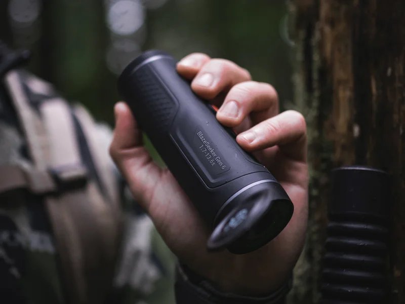 Hunter in the field using an ATN X-Sight optic at dusk